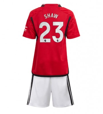 Manchester United Luke Shaw #23 Primera Equipación Niños 2023-24 Manga Corta (+ Pantalones cortos)